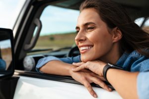 Happy attractive young woman in the window